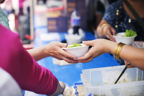 Helping People With Hunger With Kindness : the concept of life problems, hunger in society : concept of charity food for the poor : Hand-feeding to the needy in society