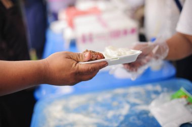 Gönüllüler yoksullara lezzetli yemekler sunar : Yiyecek bağışlayarak toplumda yoksullara yardım : Açlık kavramı