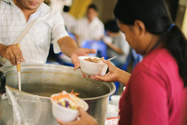 The hands of the rich give food to the hands of the poor : The concept of sharing : Volunteers Share Food to the Poor