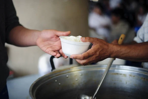 The hands of the rich give food to the hands of the poor : The concept of sharing : Volunteers Share Food to the Poor