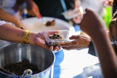 Gönüllüler dilencilere şefkatle yemek sağlamak için işbirliği içindeler..