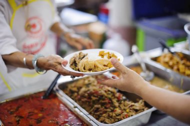 Volunteers serving food for poor people : Food sharing concept clipart