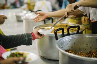 Fakir insanlar yemek yemek ve açlık rahatlatmak ve eve getirmek için yiyecek kepçe bir konteyner getirmek.