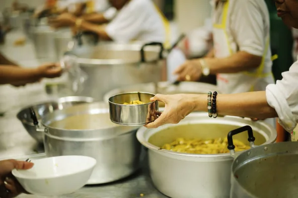 Hands of volunteers serves free food to the poor and needy in the city