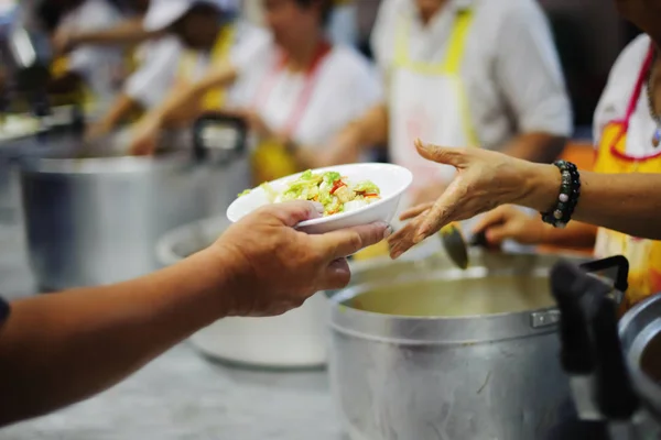 Hands of beggars accepting food from the hands of volunteers who come to help free food breaks.