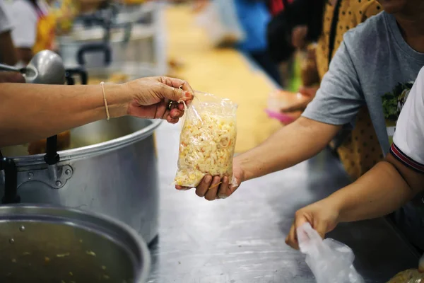 The hands of beggars receive donated food as a share in society : the concept of hunger