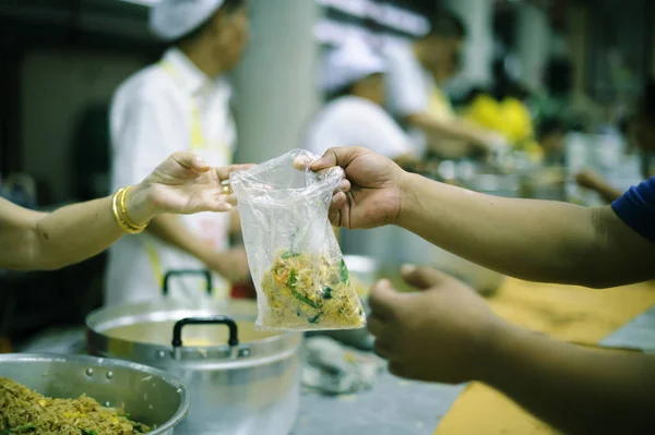 The hands of beggars receive donated food as a share in society : the concept of hunger