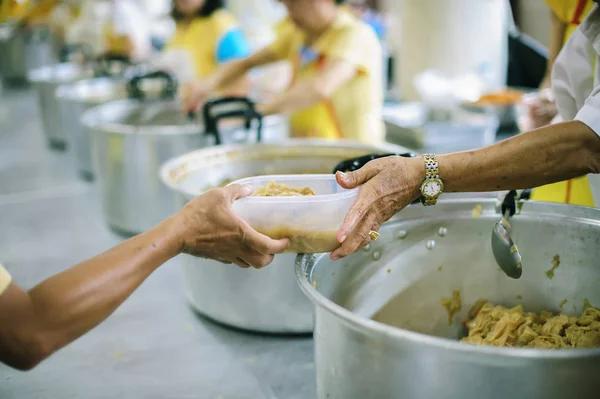 The hands of the poor receive food from the hands of the philanthropist : concept of giving