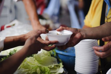 Fakirlerin elleri hayırseverden yiyecek alır. Paylaşım konsepti