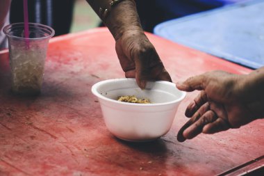 Evsiz ve yardıma muhtaç insanlar, gönüllülerden yiyecek yardımı alıyor: gıda bağışı kavramı.