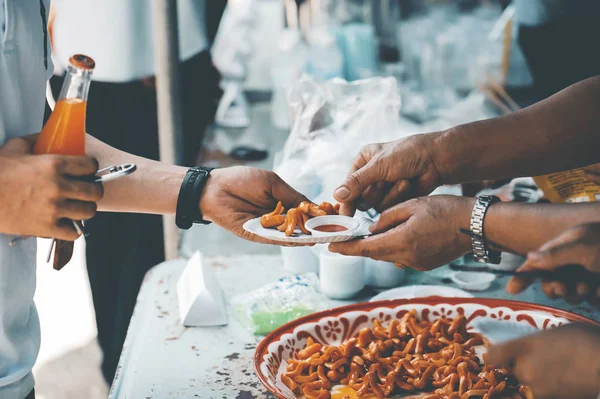 Volunteers give food to the poor to alleviate hunger : the concept of giving food