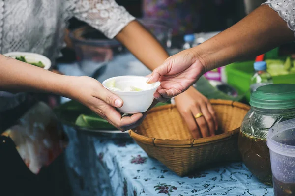 Volunteers serving food for poor people : concept of free food serving