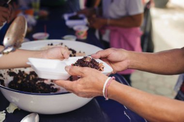 Ücretsiz gıda molalarına yardım etmeye gelen gönüllülerin elinden yiyecek kabul eden dilencilerin elleri : Yoksulluğun Sosyal Sorunları Beslenmenin Yardımıyla