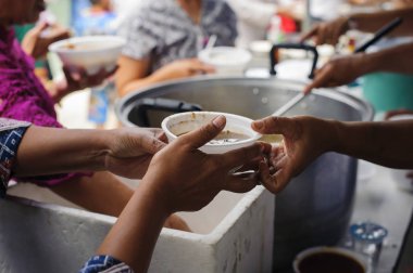 Yoksullar için açlık hafifletmek için gıda paylaşımı kavramı : Ücretsiz gıda molaları yardım için gelen gönüllülerin elinden gıda kabul dilenci eller