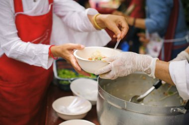 Yoksullar için açlık hafifletmek için gıda paylaşımı kavramı : Ücretsiz gıda molaları yardım için gelen gönüllülerin elinden gıda kabul dilenci eller