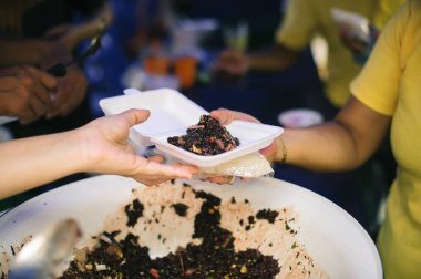 Fakir insanlar yiyecek bulmak, açlığı gidermek ve eve getirmek için bir konteynır getiriyorlar: toplumun birbirini paylaşma konsepti