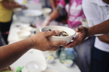 Fakir insanlar yiyecek bulmak, açlığı gidermek ve eve getirmek için bir konteynır getiriyorlar: toplumun birbirini paylaşma konsepti