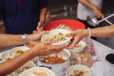 Fakir insanlar yiyecek bulmak, açlığı gidermek ve eve getirmek için bir konteynır getiriyorlar: toplumun birbirini paylaşma konsepti