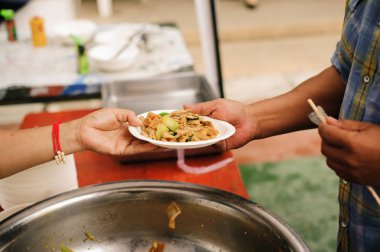 Fakir insanlar yiyecek bulmak, açlığı gidermek ve eve getirmek için bir konteynır getiriyorlar: toplumun birbirini paylaşma konsepti