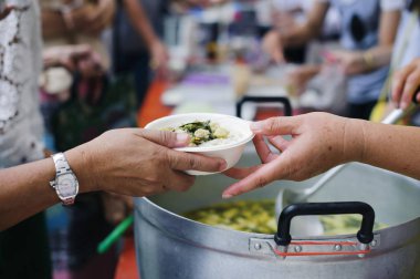 Dilencilerin elleri yiyecek kıtlığı kavramına bağışlanmış yiyecekler alır.