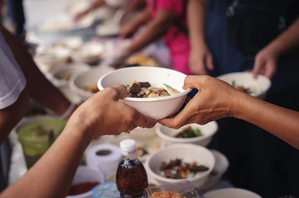 Charity food is free for people in slums : Hands of volunteers serves free food to the poor and needy in the city