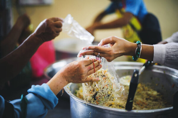 The Hands of the Poor Receive Charity Food Service from Volunteers :  The Concept of Poverty and Hungry