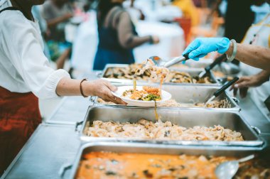 Evsiz ve yardıma muhtaç insanlar, gönüllülerden yiyecek yardımı alıyor: gıda bağışı kavramı.