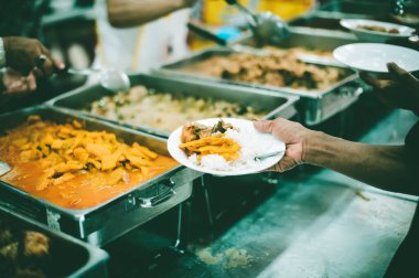 Evsiz ve yardıma muhtaç insanlar, gönüllülerden yiyecek yardımı alıyor: gıda bağışı kavramı.