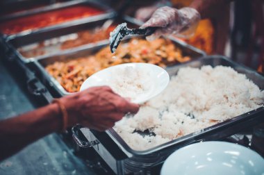 Yoksulların elleri donörden yiyecek bağışlamak için yalvarıyor: