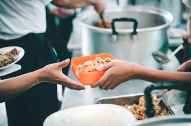 Gönüllülerin elleri fakirlere bedava yemek veriyor.