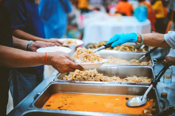 ボランティアの手は貧しい人々に無料の食べ物を提供します — ストック写真