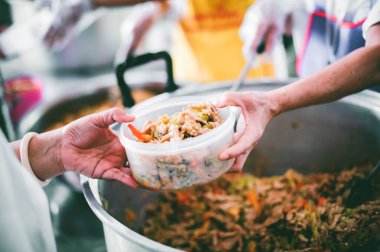 Gönüllüler Açlığı Dindirmek İçin Yiyeceği Fakirlere Paylaşır: Bağış gıda konsepti