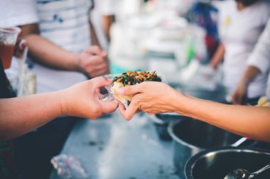 Gönüllüler Açlığı Dindirmek İçin Yiyeceği Fakirlere Paylaşır: Bağış gıda konsepti