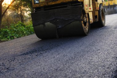 Asfalt kaldırımındaki ağır titreşimli paten sıkıştırıcısı yol onarımı için çalışıyor