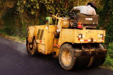 Asfalt kaldırımındaki ağır titreşimli paten sıkıştırıcısı yol onarımı için çalışıyor