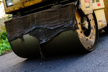 Asfalt kaldırımındaki ağır titreşimli paten sıkıştırıcısı yol onarımı için çalışıyor