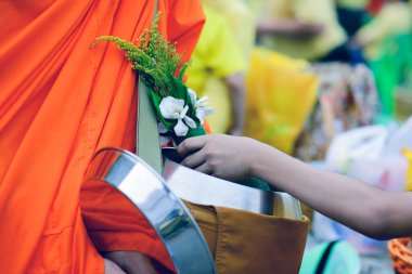 Budistler, Budist inanışlarına göre rahiplere erdem kazandırmak için keşişlere yiyecek ve çiçek getirirler..