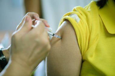 Hastalar gribe karşı bağışıklık kazanmak için kollarına aşı olurlar: iyileştirme ve sağlık hizmeti kavramı.