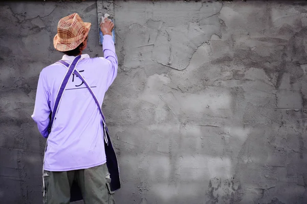 Duvara alçı yapıştırarak pürüzsüz bir yüzeye sahip bir sıvacı işi..