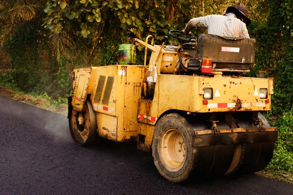 Asfalt kaldırımındaki ağır titreşimli paten sıkıştırıcısı yol onarımı için çalışıyor