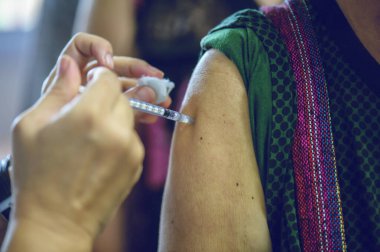 Koluna iğne batırılmış bir doktordan grip aşısı alıyorum..