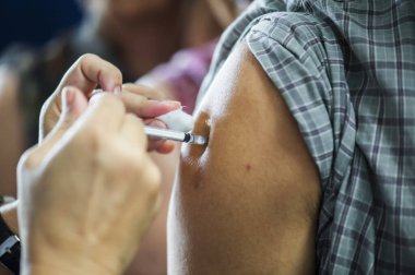 Koluna iğne batırılmış bir doktordan grip aşısı alıyorum..