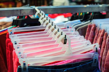 Giysiler bir giyim mağazasında rafta asılı.