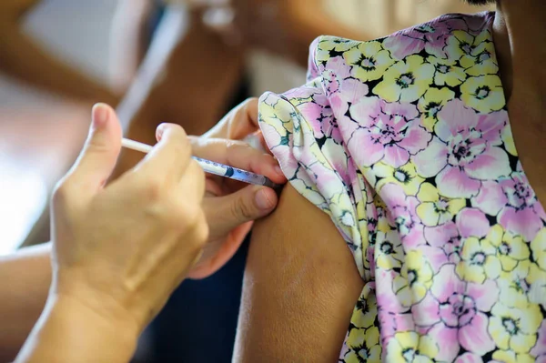 Koluna iğne batırılmış bir doktordan grip aşısı alıyorum..