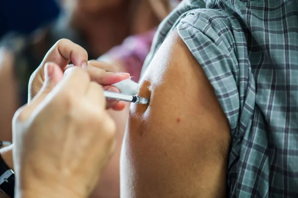 Koluna iğne batırılmış bir doktordan grip aşısı alıyorum..