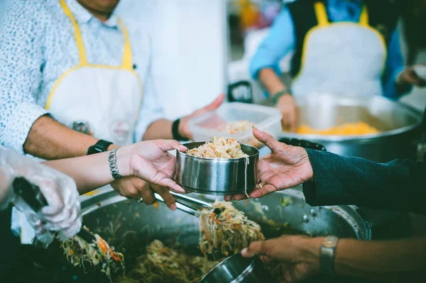 The donor gives warm food to the poor : concept of sharing food