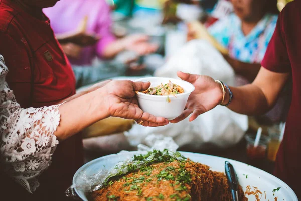 The donor gives warm food to the poor : concept of sharing food