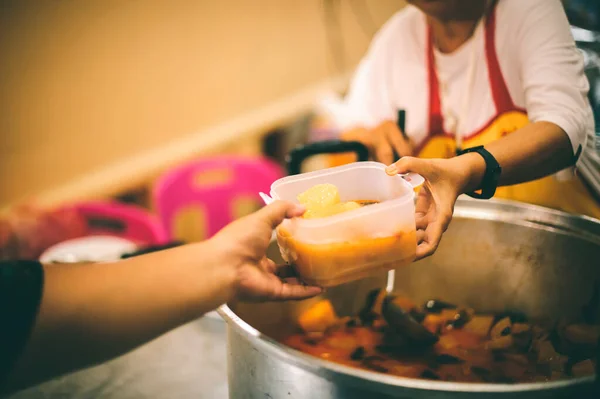 Food donation to help people in hunger relief : hands of the poor receive food from the donor's share