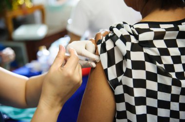 Aşı aşısı, doktor hasta koluna aşı enjekte ediyor.