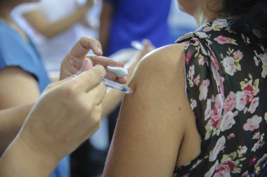 Aşı aşısı, doktor hasta koluna aşı enjekte ediyor.